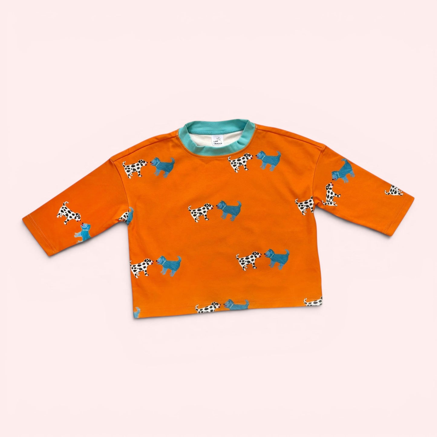 Orange long-sleeve shirt with dog pattern on a white background